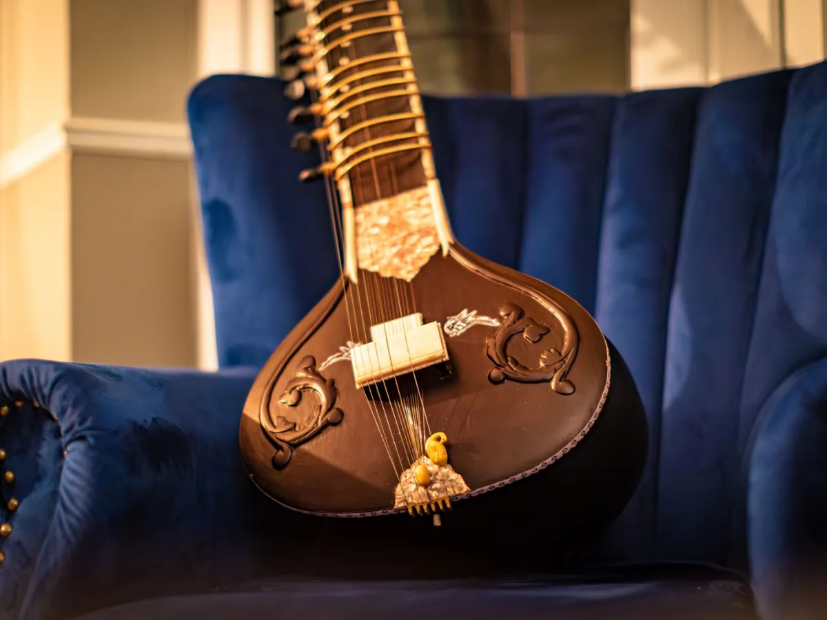 A sitar resting on an armchair in warm evening light before a performance